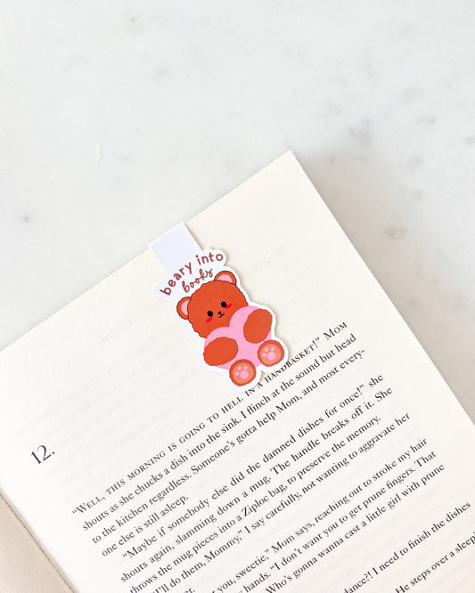 Book with a teddy bear bookmark on a white background